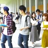 A group of students attending a prestigious university in the Kansai region. They are actively engaged in their academic and social life, representing the high academic standards and student engagement of the institution. The setting shows modern campus facilities, with students studying, walking, and enjoying university life in a vibrant and intellectual environment. The students should be Japanese, reflecting the local culture.