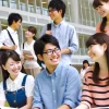 A modern university campus in Kansai, Japan, featuring bright, high-achieving, and friendly Japanese students. The students are engaged in collaborative learning, smiling and enjoying a supportive academic environment. The atmosphere is positive, inclusive, and shows camaraderie among students in a contemporary setting.